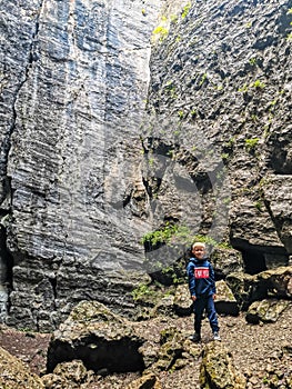 A boy in the Stone Bowl Gorge. A gorge in the mountains of the landscape nature of Dagestan. Russia.
