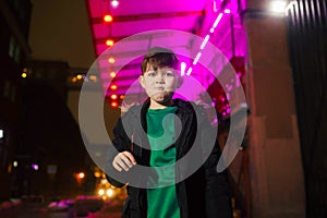 The boy on the street in neon lighting. City in neon light