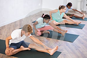 Boy stretches and prepares to perform Jana Shirshasana