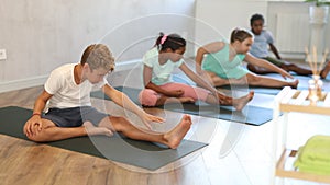 Boy stretches and prepares to perform Jana Shirshasana