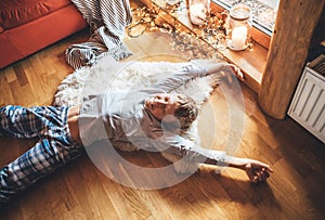 Boy stretching himself lying on floor on sheepskin and looking in window in cozy home atmosphere. Peaceful Lazy moments in cozy