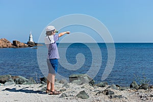 A boy in a striped T-shirt and a cap.