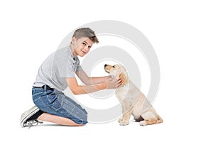 Boy stroking dog while kneeling