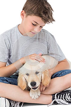 Boy stroking dog over white background