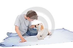 Boy stroking puppy on blanket