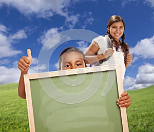 Boy student gives Thumbs Up Holding Blank Chalk Board