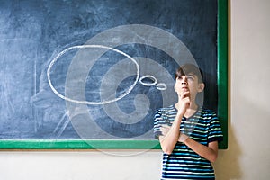 Boy Student Leaning On Blackboard And Thinking In Classroom