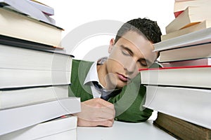 Boy student sleeping over stack books over desk