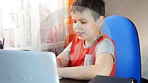 Boy studies at home at the computer. remote education, school child learns lessons online using video broadcasting and