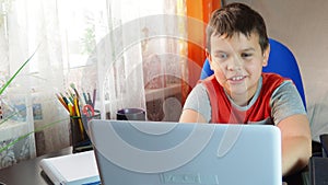 boy studies at home at the computer. remote education, school child learns lessons online using video broadcasting and