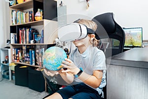 Boy studies space with help of technology and app. Kid in Virtual reality headset learning Solar system planets at home