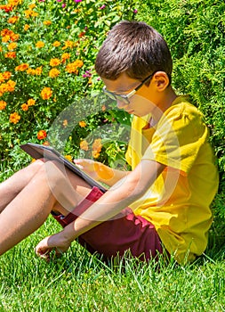 Boy studing in a park reading information on a table