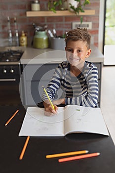 Boy studying at table in kitchen at home