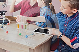 Boy studying with tablet and lab equipment