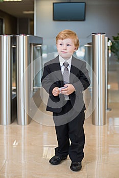A boy in a suit at the entrance to the business