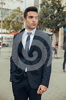 Boy in suit smoking with vaper