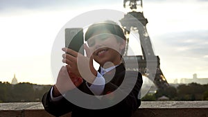 Boy in a suit taking selfie photo with smartphone