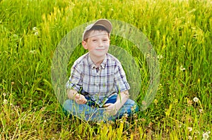 Boy on summer nature with dandelions