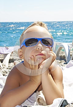 The boy in a sun glasses on a beach