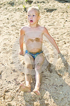 Boy sunbathes on the sand