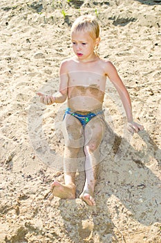 Boy sunbathes on the sand