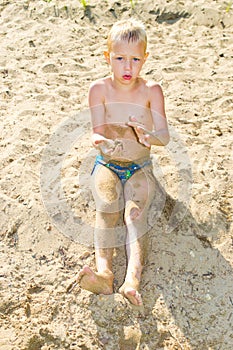 Boy sunbathes on the sand