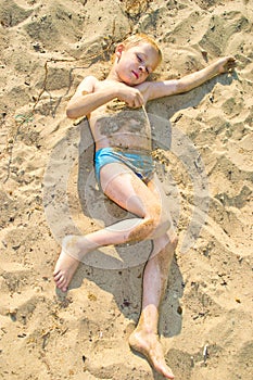 Boy sunbathes on the sand
