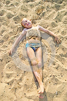 Boy sunbathes on the sand