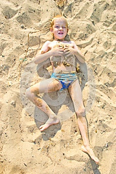 Boy sunbathes on the sand