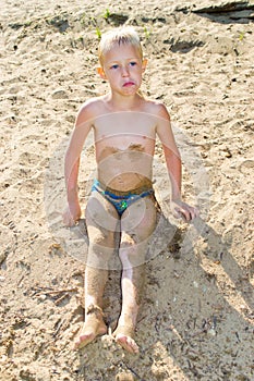 Boy sunbathes on the sand