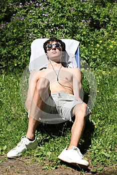 Boy sunbathing on  showing middle finger with copy space for your text