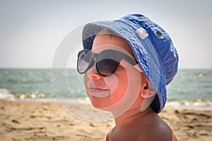 Boy in sunglasses on the beach