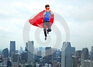 Boy in super hero cape and mask showing thumbs up