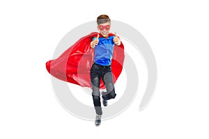 Boy in super hero cape and mask showing thumbs up