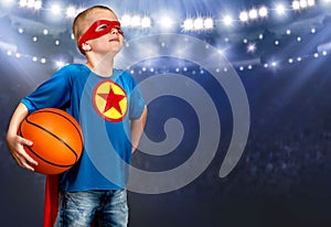 A boy in a superhero costume plays basketball.
