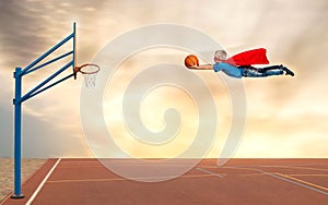 A boy in a superhero costume plays basketball and flies to throw the ball into the basket.