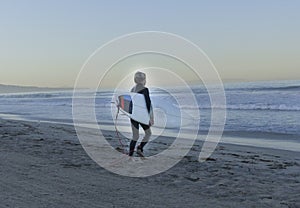 Boy Surfer Walking Into Ocean photo