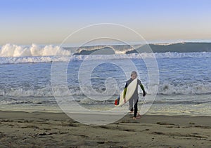 Boy Surfer Walking Out Of Ocean Surf photo