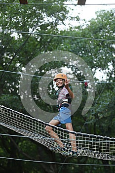 Boy surmounting obstacle course in the outdoor rope park photo