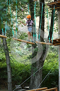 Boy surmounting obstacle course in the outdoor rope park photo