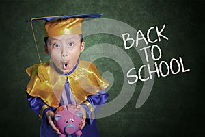 Boy surprise holding piggybank in class