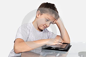 Boy with surprise looks at tablet computer