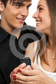 Boy surprising girlfriend with diamond ring.