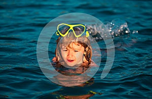 Boy swim on the beach on summer holidays. Happy kids swimming in the water. Little boy swimming in ocean or sea.