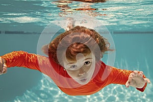 Boy swim and dive underwater. Under water portrait in swim pool. Child boy diving into a swimming pool.