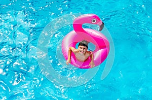 Boy swim in inflatable flamingo view from above