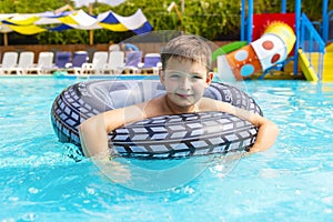 Boy swim on inflatable ring in swimming pool outdoors