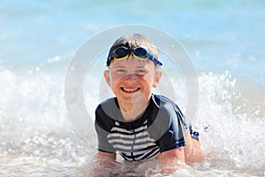The boy swiming in sea waves