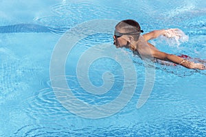 Boy swimmer swimming butterfly stroke in pool. Young athlete swim in swimming pool. Training, competition, water sports