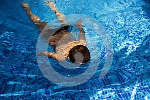 Boy swimming in blue pool